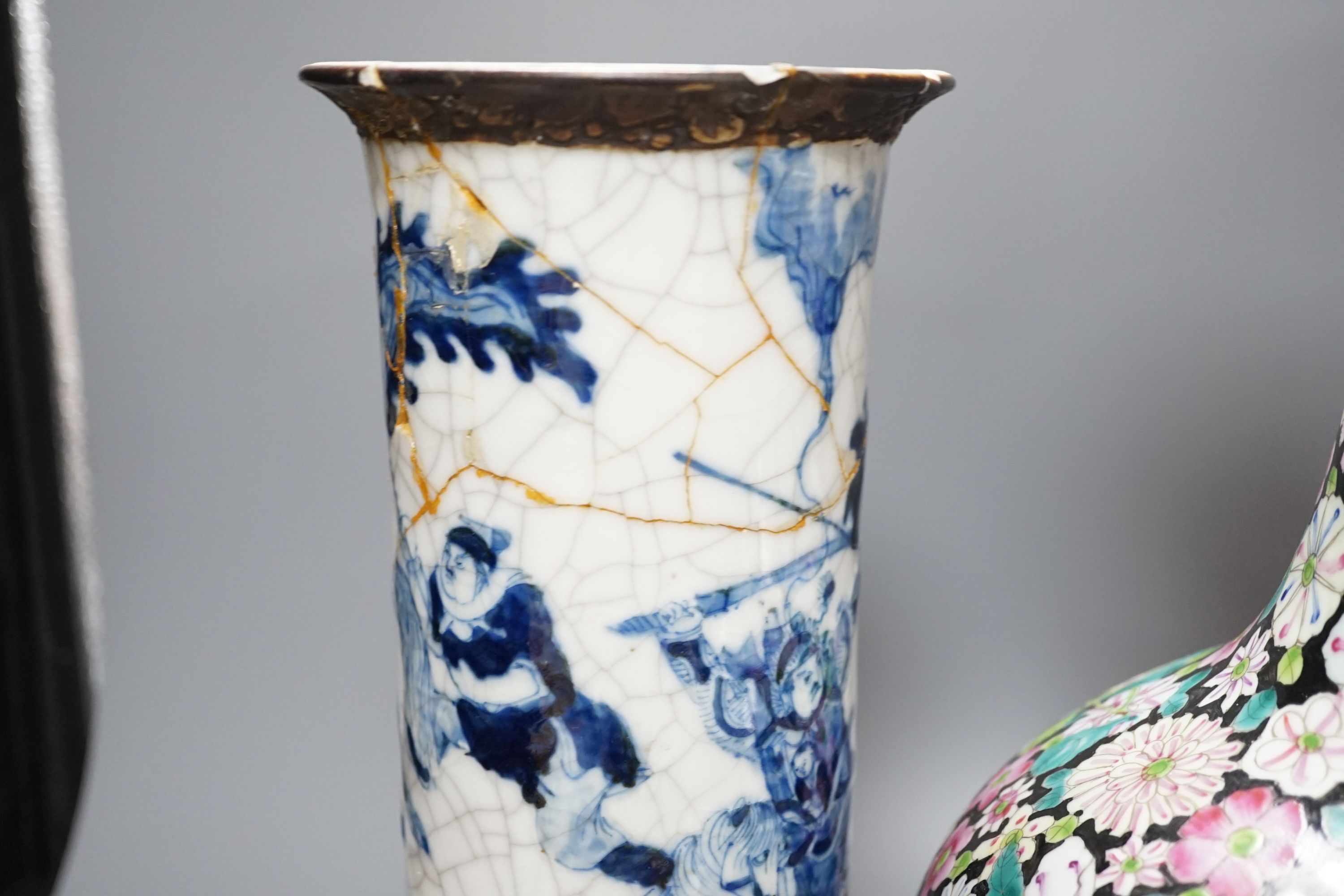 An early 20th century Chinese famille rose thousand flowers bottle vase (restored) together with a Chinese blue and white crackle glazed sleeve vase (a.f)., tallest 40cm
